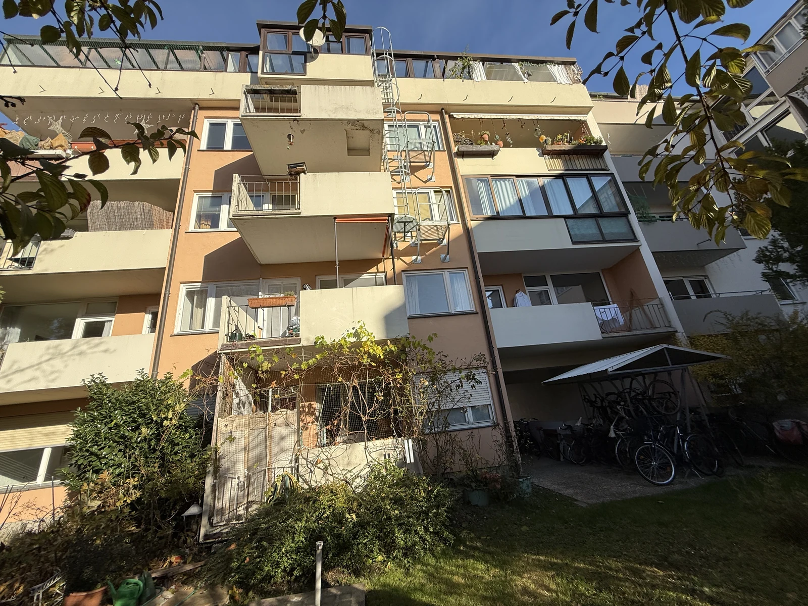 Rückwärtige Ansicht eines mehrgeschossigen Wohnhauses mit Balkonen, Loggien und Dachwohnungen