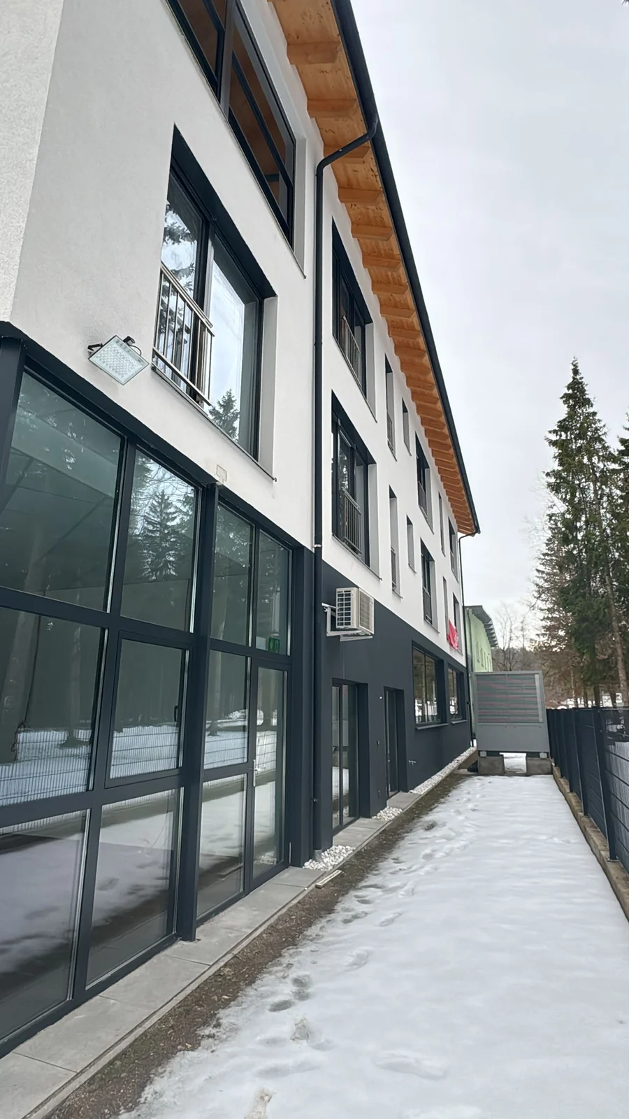 Mehrgeschossige Gewerbefassade mit großen Fensterflächen und separaten Eingängen