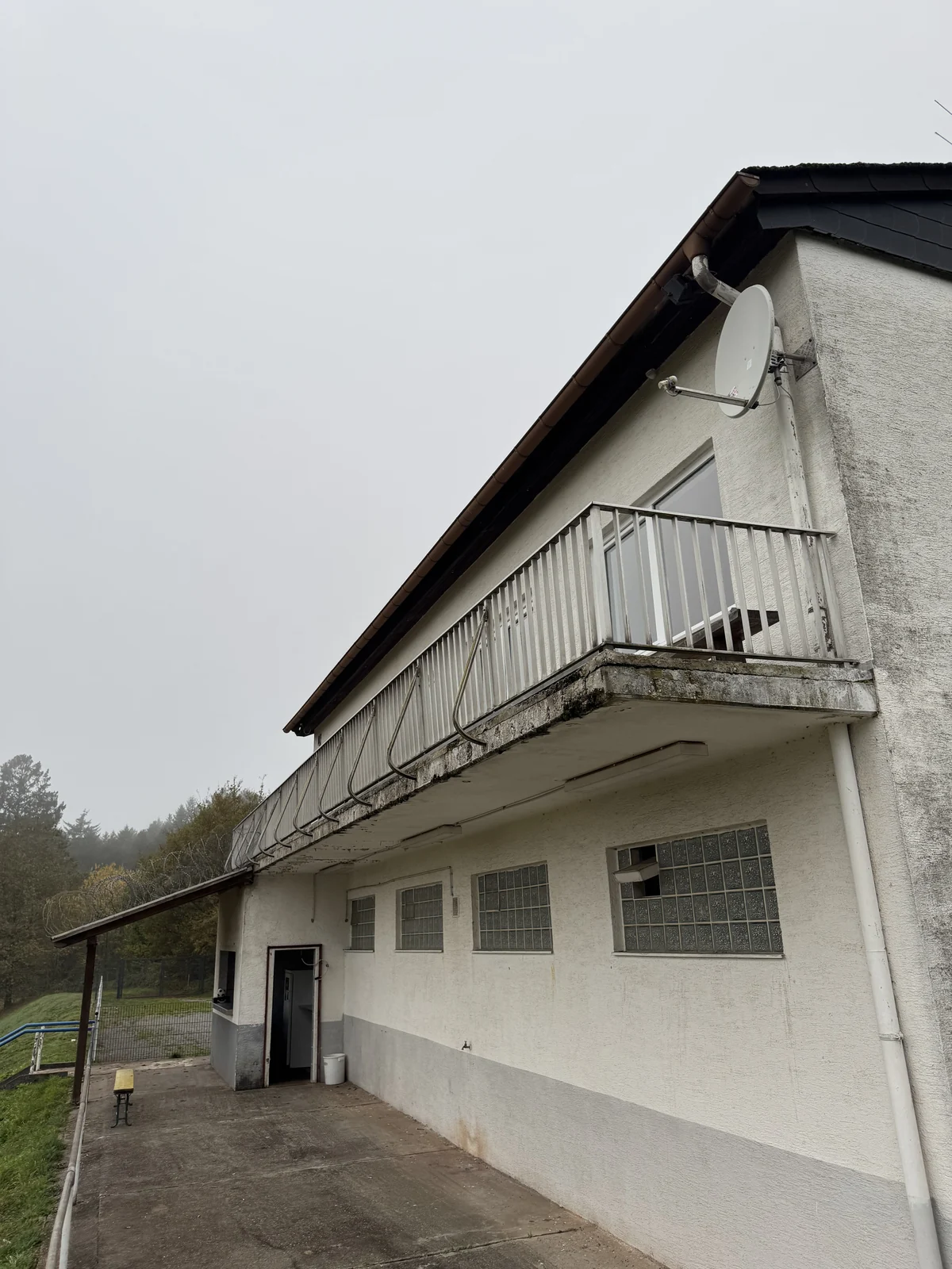 Vereinsgebäude mit langem Balkon, Putzfassade und mehreren Eingängen