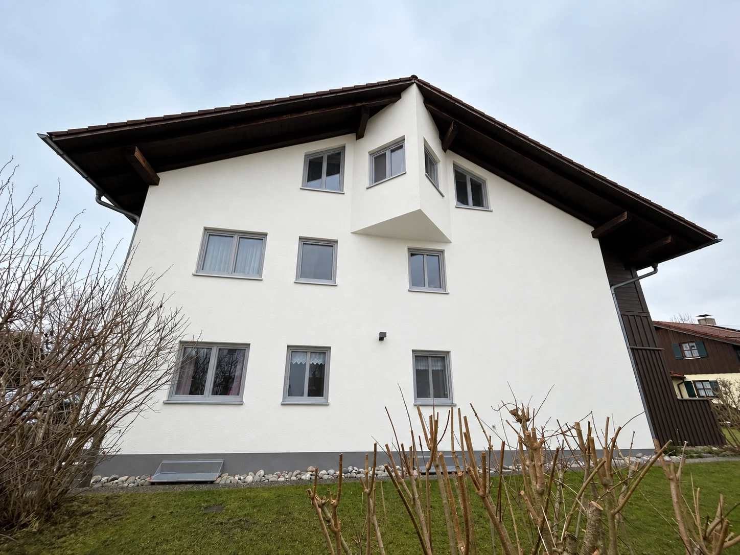Visualisierung desselben Wohnhauses mit erneuerter Putzfassade, hellgrauen Fenstern und abgestimmtem Sockel